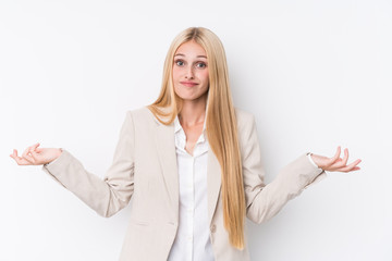 Young business blonde woman on white background doubting and shrugging shoulders in questioning gesture.