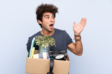 Man making a move while picking up a box full of things with surprise facial expression