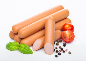Classic boiled meat pork sausages with pepper and basil and cherry tomatoes on white background.