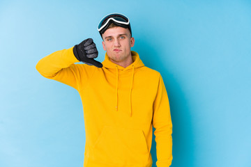 Young skier man showing a dislike gesture, thumbs down. Disagreement concept.