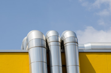 heating system or utility lines on a building. The pipes of the service system on the roof are covered with a galvanized steel cover.
