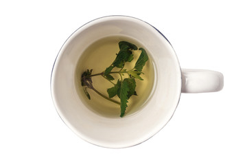 Fresh fragrant herbal tea made from green leaves of Melissa in ceramic mug isolated on white. Traditional, therapeutic, relaxing, calming, healthy, organic, delicious drink