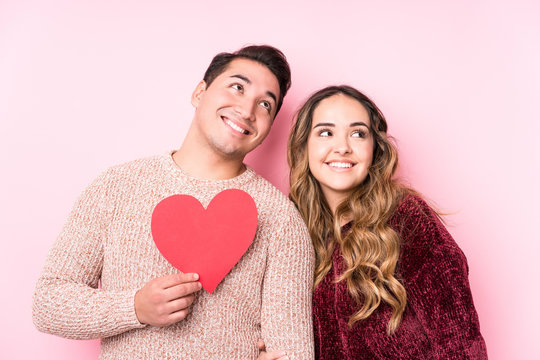 Young Latin Couple Holding A Heart Sticker