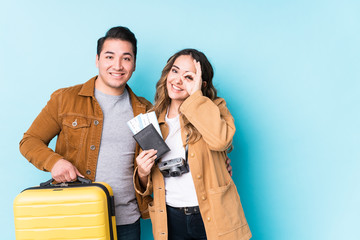 Young couple ready for a travel isolated excited keeping ok gesture on eye.