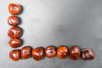 Fresh chestnut fruit scattered on stone background. Top view. With your place for text