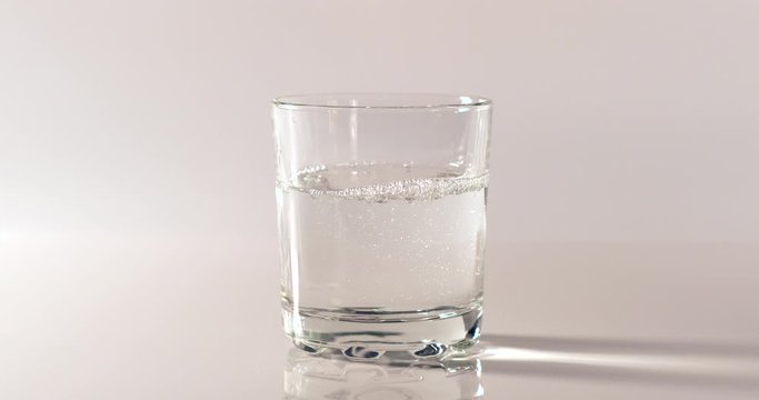Pouring fresh pure water into a clear glass on white background. Health and diet concept. Water filling into transparent glass