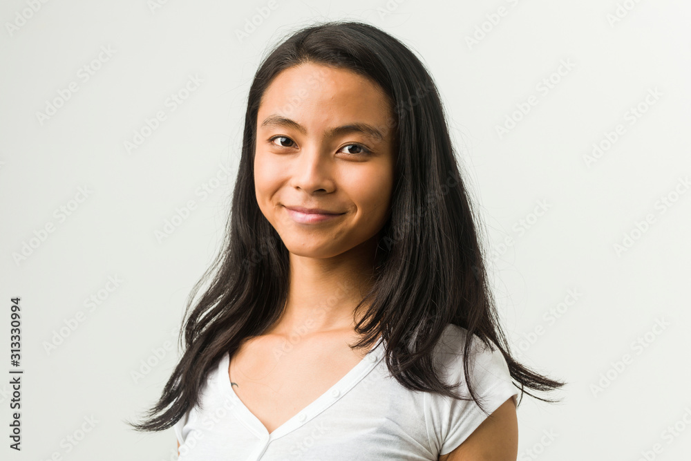 Wall mural Young chinese woman posing on a white background