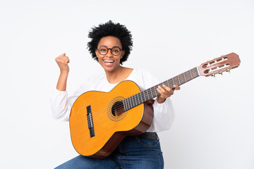 African american woman with guitar over isolated background celebrating a victory