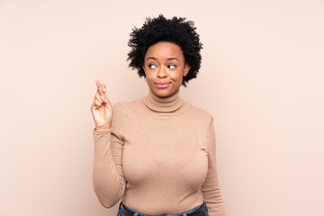 African american woman over isolated background with fingers crossing and wishing the best