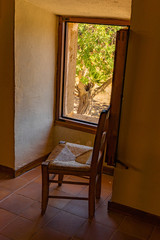 Old wooden chair in front of open window