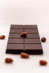 Dark chocolate with whole hazelnuts isolated on white background