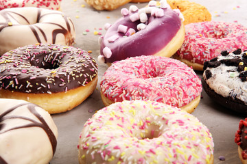 assorted donuts with chocolate frosted, pink glazed and sprinkles donuts