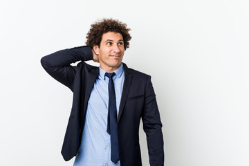 Young business curly man against white background touching back of head, thinking and making a choice.