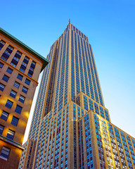 Bottom up Street view on Financial District of Lower Manhattan, New York City, NYC, USA. Skyscrapers tall glass buildings United States of America. Blue sky on background. Empty place for copy space.