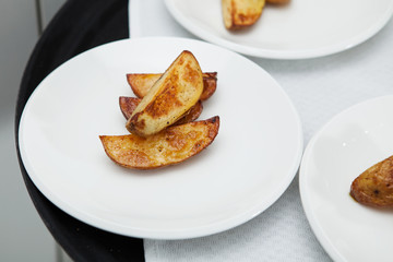 Fast food. Tasty baked potatoes on white plates.