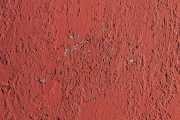 Red peeling paint on a metal surface. Texture.