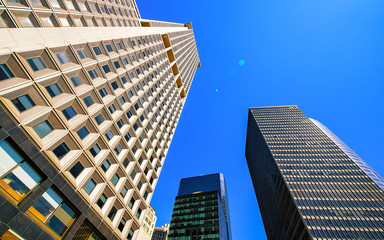 Obraz na płótnie Canvas Bottom up Street view on Financial District of Lower Manhattan, New York City, NYC, USA. Skyscrapers tall glass buildings United States of America. Blue sky on background. Empty place for copy space.