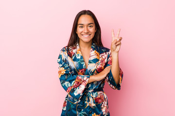 Young indian woman wearing a kimono pajama showing number two with fingers.