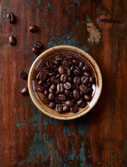 Coffee beans on rustic wooden background. Top view. 