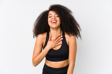 Fototapeta na wymiar Young african american sporty woman laughs out loudly keeping hand on chest.
