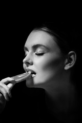 Girl holding orange slice, studio shot of young woman portrait with orange close up, seasonal healthy food fruit. Black and white photo