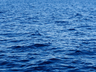 Background texture of vivid blue ocean water with ripples and waves.