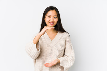 Obraz premium Young chinese woman isolated holding something with both hands, product presentation.