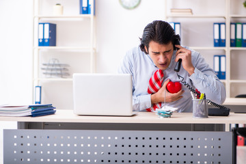 Young male employee suffering in the office