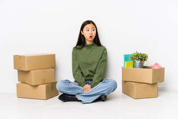Young chinese woman moving to a new home being shocked because of something she has seen.