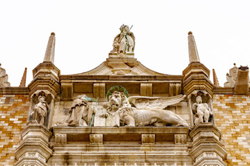 Sculpture/ Statue of winged lion (Symbol of Venice) and Doge Francesco Foscari on the famous brick wall exterior facade of Doges Palace in San Marco Piazza Square, Venice city, Italy.