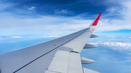 Fototapeta premium Plane wing on the blue sky and clouds,can be used for air transport to travel and open season to travel background.