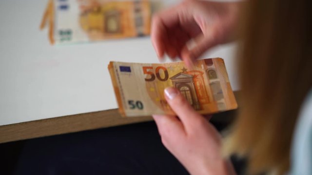 junge Frau z&auml;hlt Geld, 50 Euro Banknoten close-up