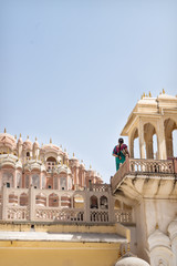 Naklejka premium Indian tourist in sari on the tower of Hawa Mahal, Palace of the Winds, Jaipur, Rajasthan, Inidia