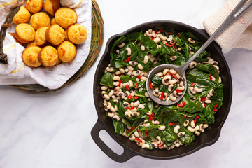 Close up of black-eye peas and collard greens with corn bead muffins