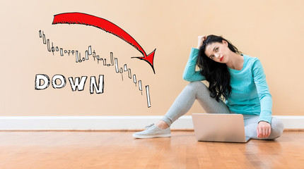 Market down trend chart with young woman using a laptop computer