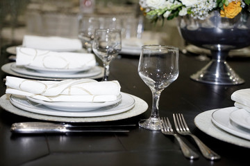 Table setting with glasses, plates, napkins and food