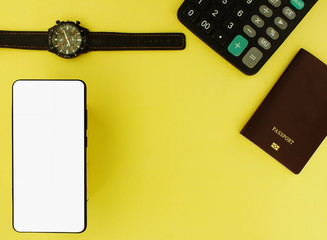 The white screen smartphone with calculator and watch on a yellow background