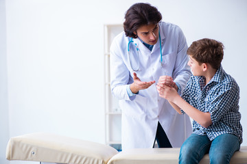 Hand injured boy visiting young male doctor