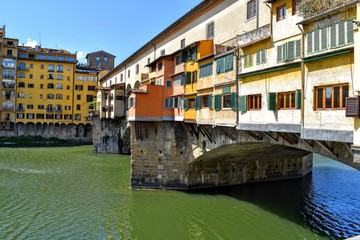 Fototapeta na wymiar Bright sunny day with green river and architectural buildings surrounding