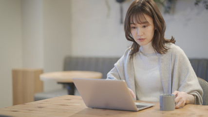 カフェでノートパソコンを操作している女性	