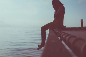 Woman sitting and feeling depression with having a headache at sea,Mental disorder health...