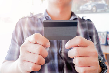Cropped shot view of woman or man hands holding credit card, typing on laptop computer keyboard for internet banking and payment with phone. Online shopping.
