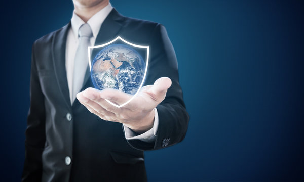 Businessman holding globe with shield icons. Protect the world and environmental conservation. Element of this image are furnished by NASA