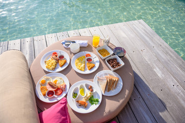 Fototapeta na wymiar Luxury breakfast on sea with beautiful tropical Maldives island , Morning time holiday vacation concept.