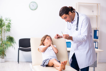 Fototapeta premium Young doctor pediatrician with small girl