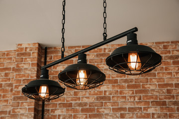 Vintage dome light using filament tungsten gives a warm orange glow in a restaurant decorated with...
