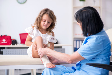 Little girl visiting old female doctor