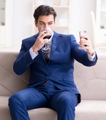 Businessman drinking wine sitting at home