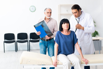 Old couple visiting young male doctor