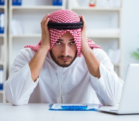 Arab businessman working in the office doing paperwork with a pi